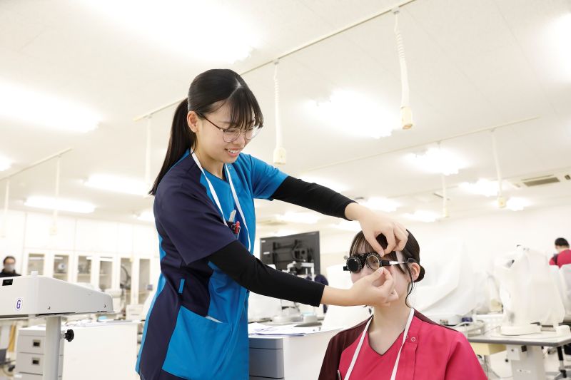 視能訓練学科の学生が実習を行っている様子。眼鏡の調節を行っている。